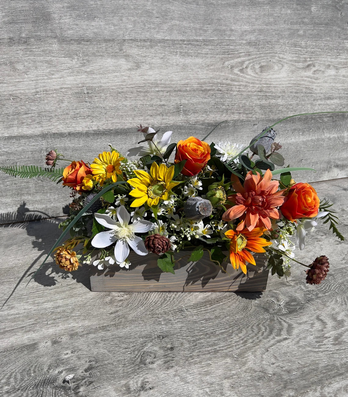 Artificial flowers in a wooden gray rectangular box
