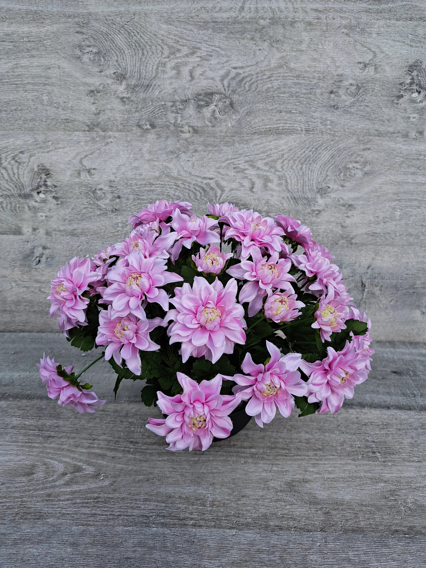 Artificial pink chrysanths flower arrangement for grave decoration.